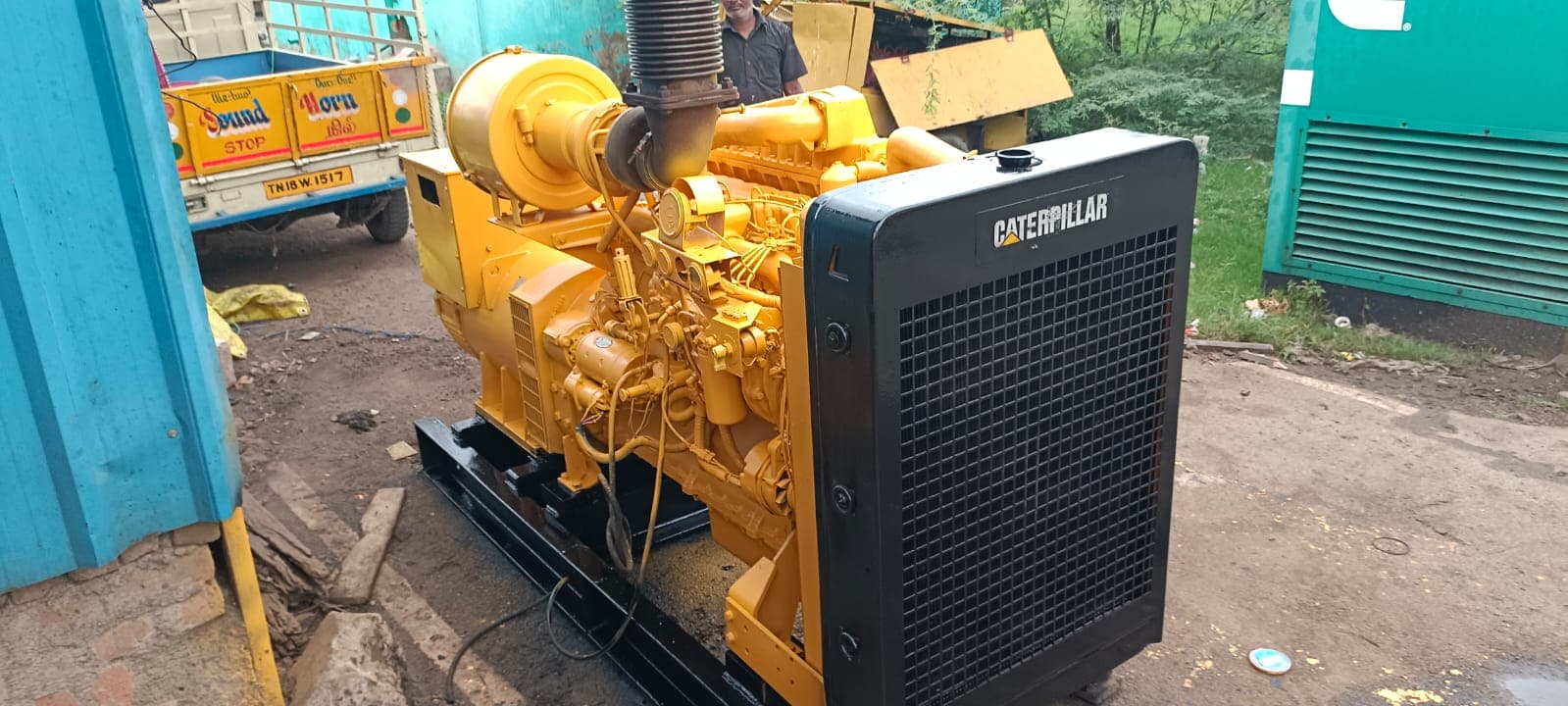Front-quarter view highlighting the heavy-duty Caterpillar radiator cowl, mechanical fuel injection lines, dual spin-on fuel filters, air intake housing, and flexible exhaust bellows.
