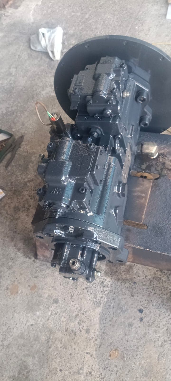Overhead perspective of the dual tandem pump showing hydraulic displacement regulator blocks, auxiliary pilot pump, and SAE mounting flange.